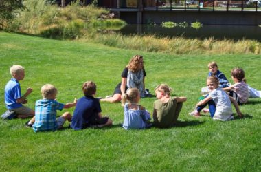 Second Grade class in a circle on the lawn