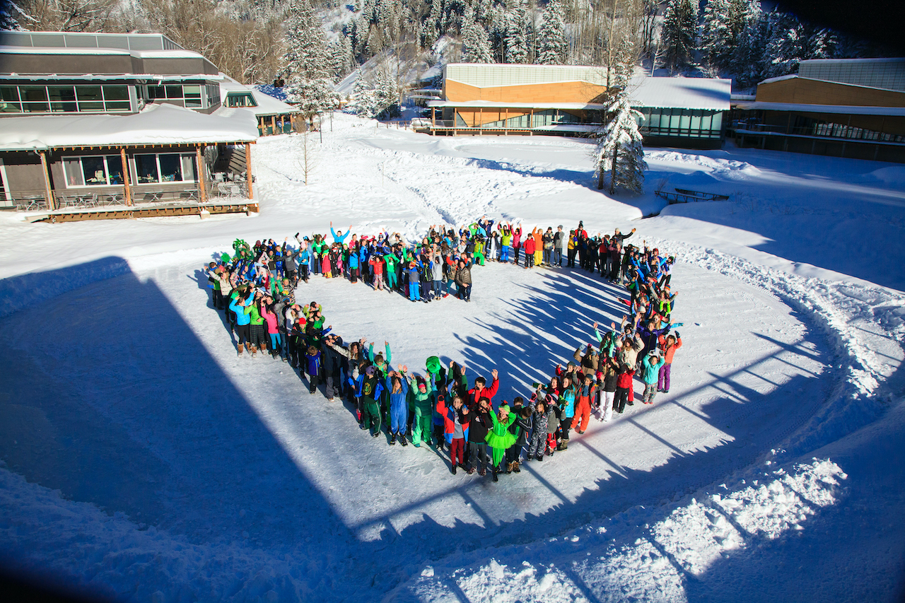students and teachers on pond in shape of heart